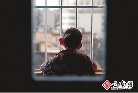 一名孩子在房間里獨自望著窗外