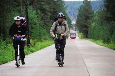竇一欣（右）和陳萌行進在北極村通往漠河縣城的公路上